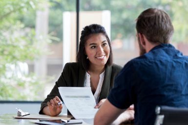 Woman at a table with a financial consultant giving client feedback. Working Feedback providing financial client feedback opportunities